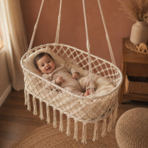 White macrame baby cradle swing hanging in nursery with soft cushion and fringe detail